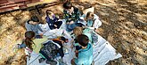 Kindergruppe mit Mitarbeiterin beim Basteln der Futtersilos